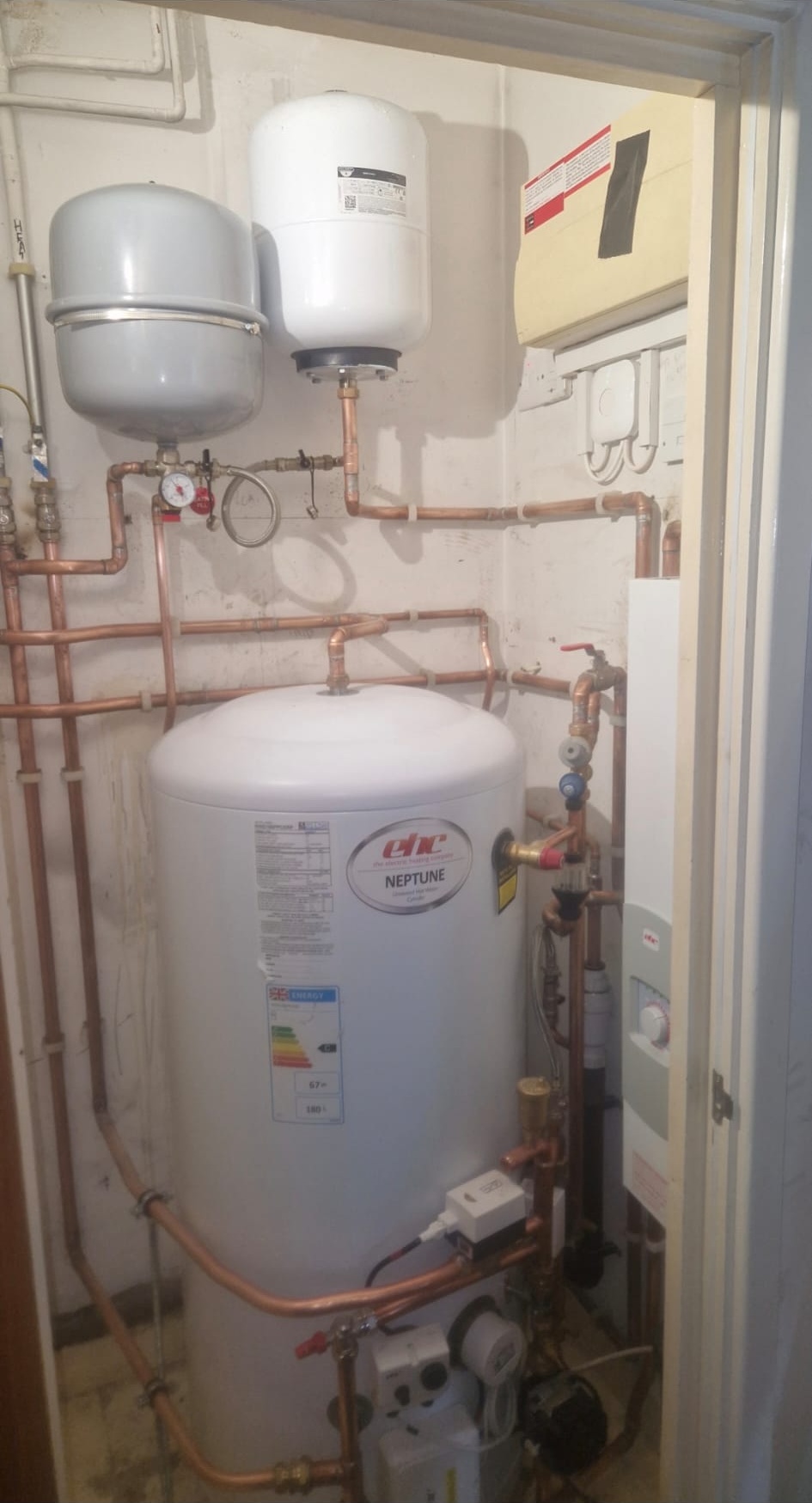 Tall unvented hot water cylinder installed in a utility plant room by G3 qualified engineers.