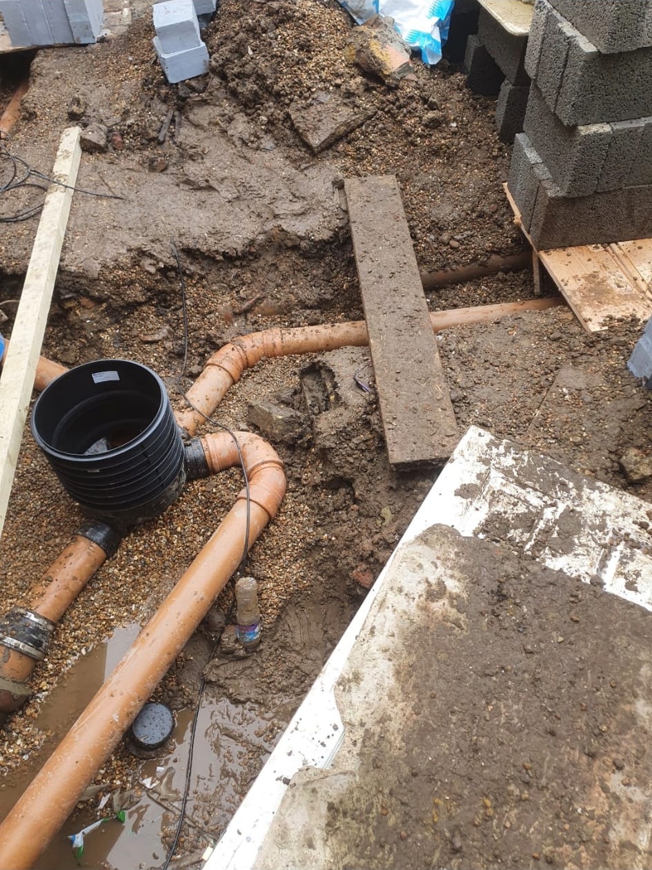 New drainage pipework and inspection chambers laid during external plumbing groundworks.